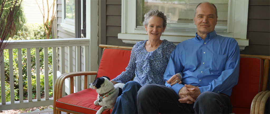 photograph of Karen Howard and Chris O'Brien sitting on a porch with their dog